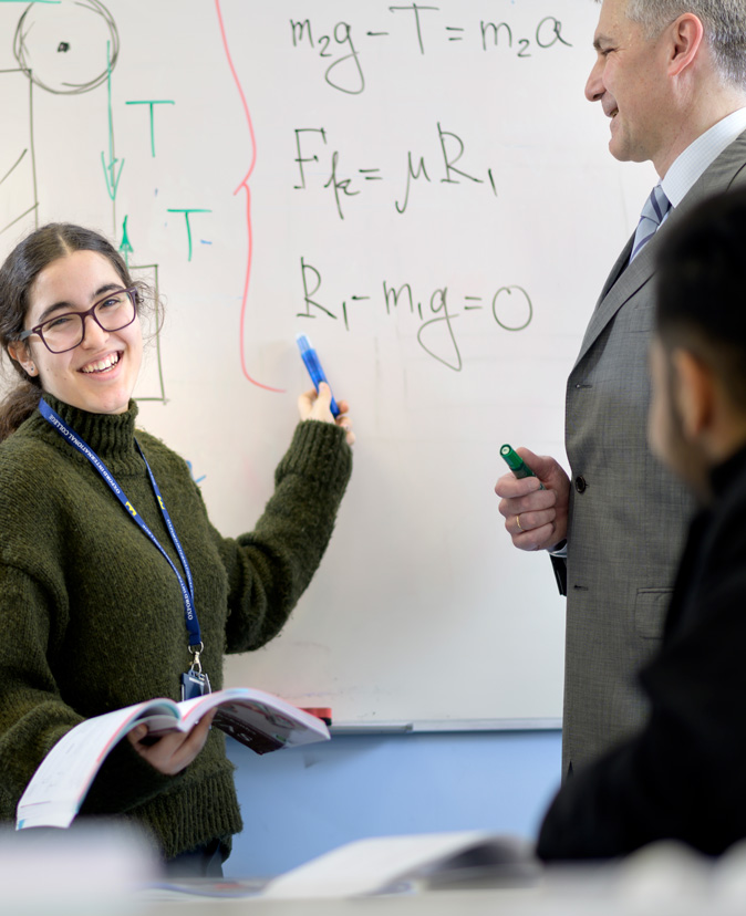 Student working out mathematical calculations at the board