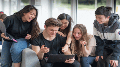 Students happily engaging together, during their studies