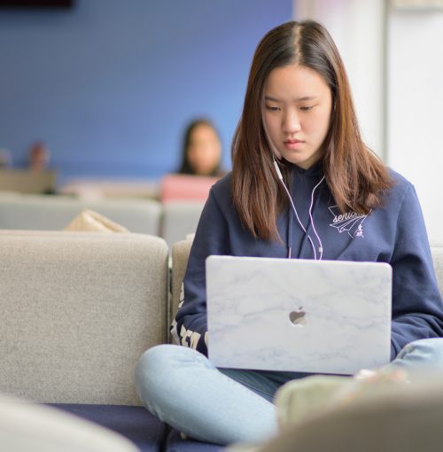 Female student, studying online, in a common space